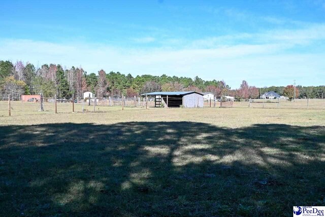 view of yard with an outdoor structure and a rural view