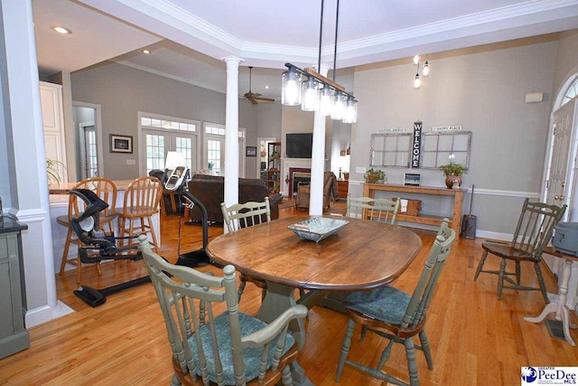 dining area featuring crown molding, light hardwood / wood-style flooring, decorative columns, and ceiling fan