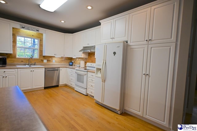 kitchen with light wood-type flooring, stainless steel appliances, sink, and white cabinets