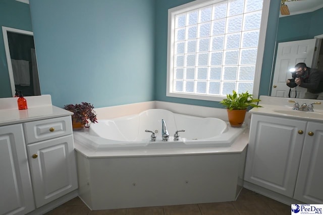 bathroom with a tub to relax in, tile patterned flooring, and vanity