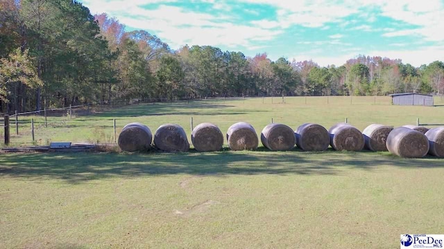 view of property's community featuring a rural view and a lawn