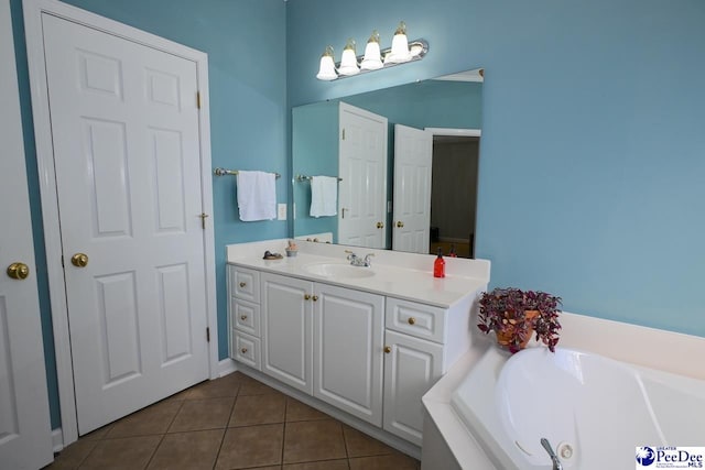 bathroom with tile patterned floors, a bathing tub, and vanity