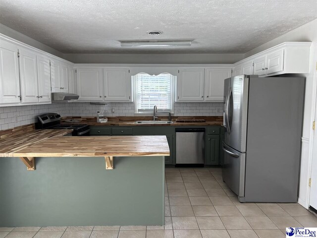 918 Fore Rd, Florence, SC 29506 - kitchen with butcher block countertops, a sink, a peninsula, stainless steel appliances, and tasteful backsplash