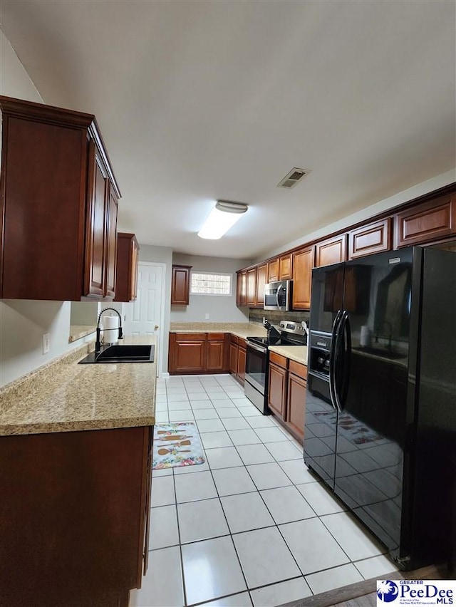 kitchen featuring appliances with stainless steel finishes, a sink, visible vents, and light tile patterned floors
