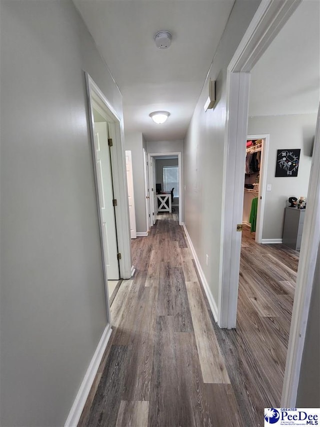 corridor featuring baseboards and wood finished floors