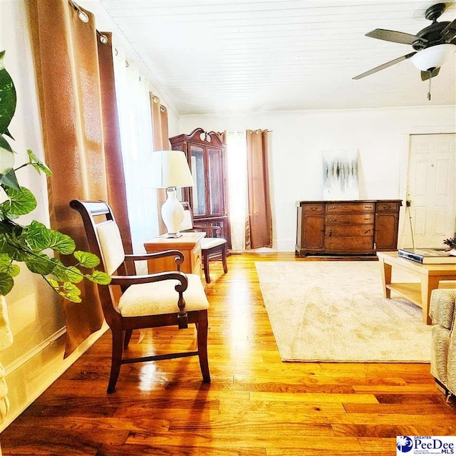 sitting room featuring wood-type flooring and ceiling fan