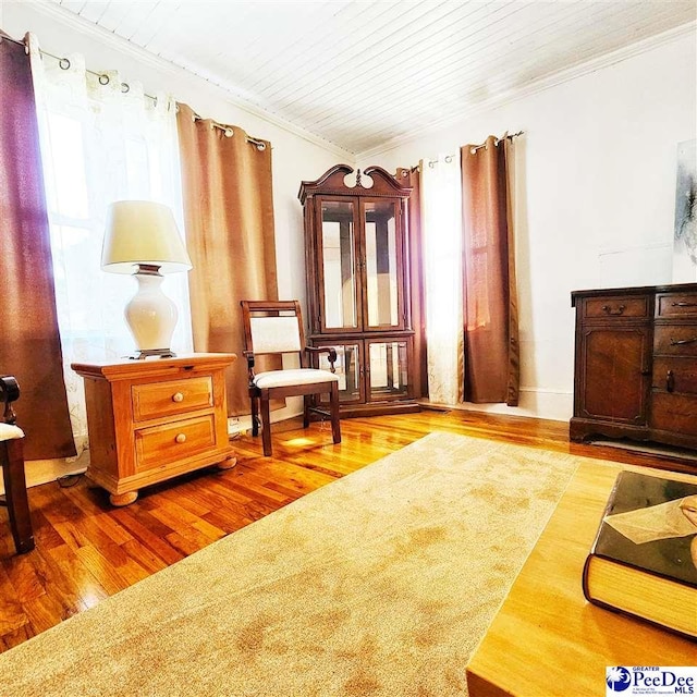 sitting room with ornamental molding, wood-type flooring, wooden ceiling, and plenty of natural light