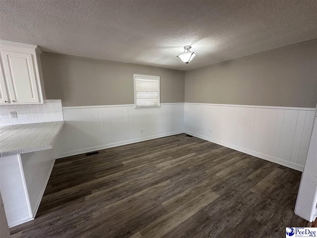 empty room featuring dark hardwood / wood-style flooring and a textured ceiling