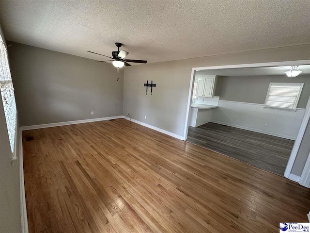 unfurnished bedroom featuring a textured ceiling, hardwood / wood-style flooring, and ceiling fan