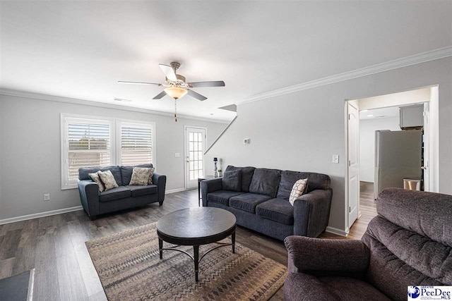 living area featuring crown molding, wood finished floors, visible vents, and baseboards