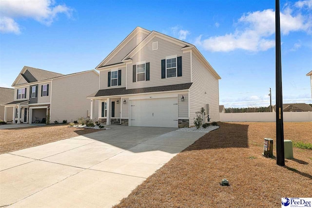 view of front of house with a garage, stone siding, fence, and driveway