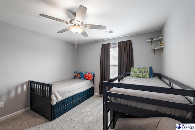 carpeted bedroom featuring a ceiling fan, visible vents, and baseboards