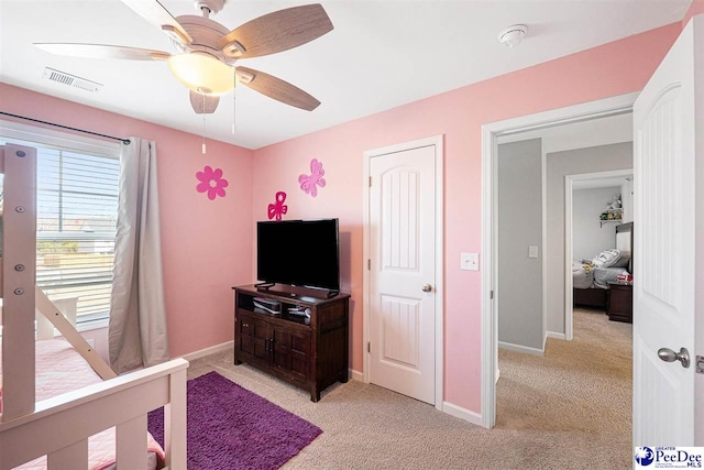 bedroom featuring a ceiling fan, light colored carpet, visible vents, and baseboards