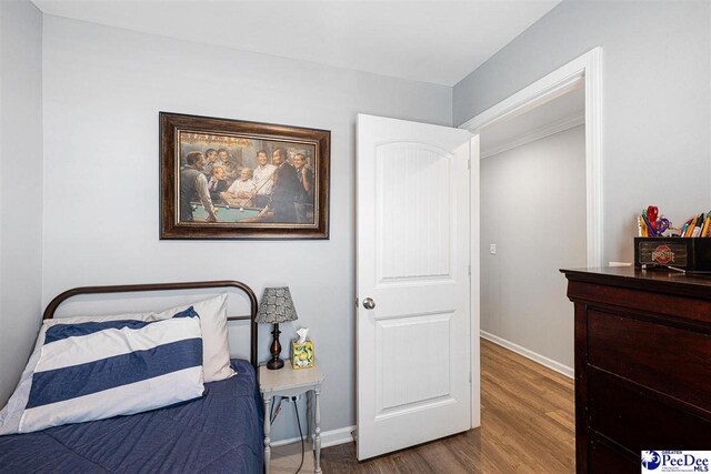 bedroom with baseboards and wood finished floors