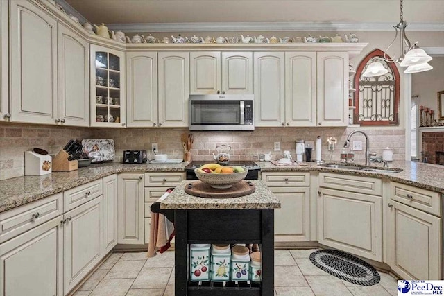 kitchen featuring crown molding, sink, backsplash, and cream cabinetry