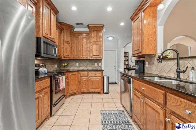 1850 Wax Myrtle Dr, Florence, SC 29501 - kitchen featuring stainless steel appliances, a sink, brown cabinetry, dark stone countertops, and recessed lighting