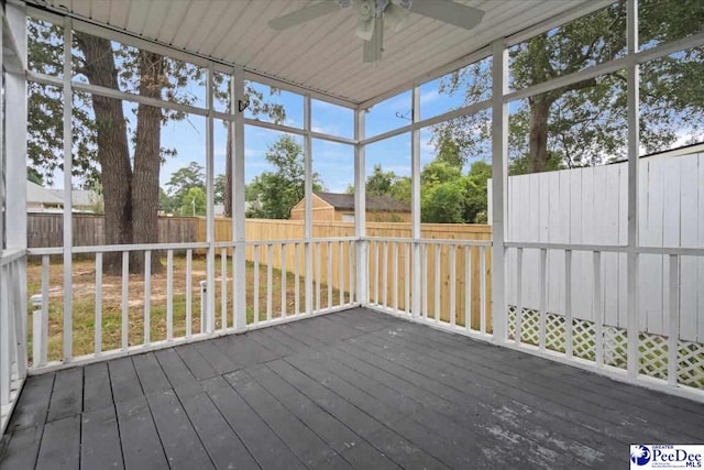 unfurnished sunroom with ceiling fan