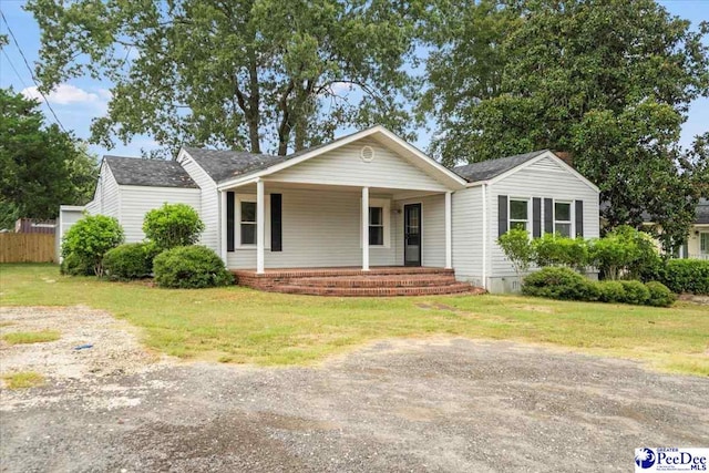 ranch-style home with covered porch and a front yard