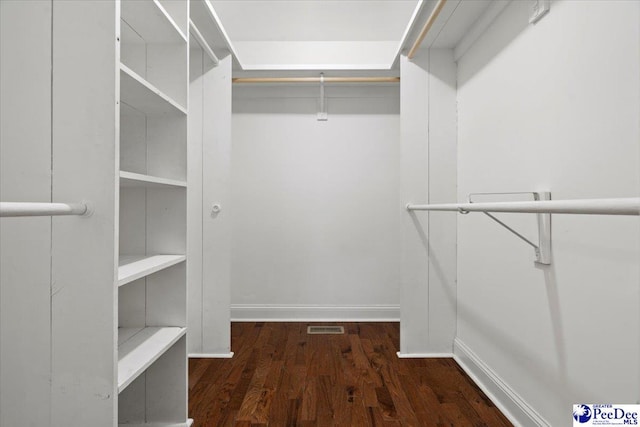 spacious closet with dark hardwood / wood-style floors