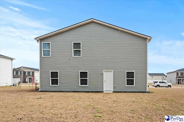 rear view of property with a lawn