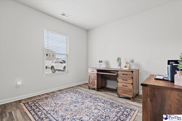 office featuring light wood-type flooring, baseboards, and visible vents