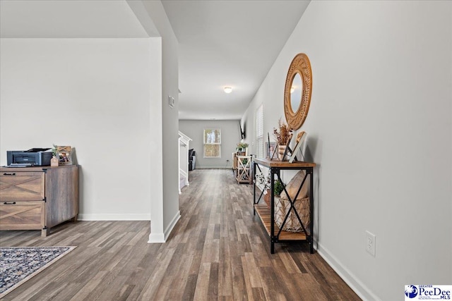 corridor featuring wood finished floors and baseboards