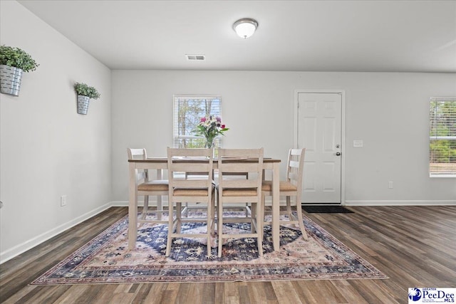 dining area with plenty of natural light, wood finished floors, visible vents, and baseboards