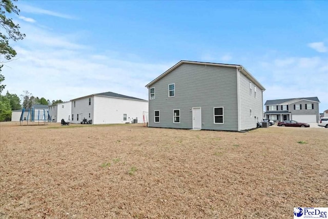 back of house featuring a yard and central AC