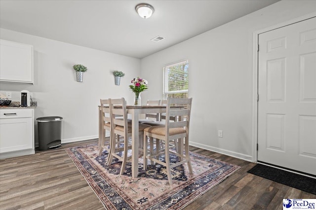 dining room featuring dark wood finished floors and baseboards