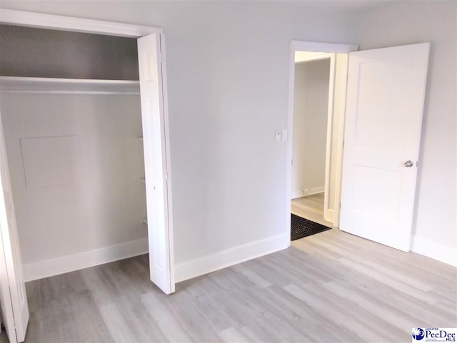 unfurnished bedroom featuring light hardwood / wood-style floors and a closet