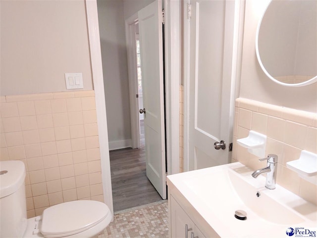 bathroom featuring tile walls, vanity, and toilet