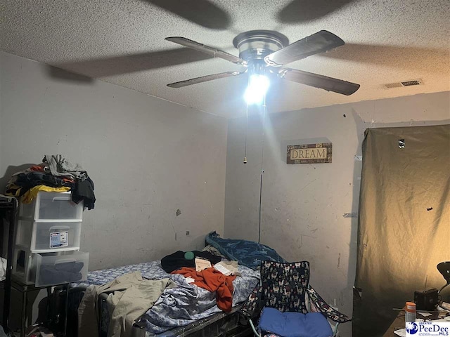 bedroom with ceiling fan and a textured ceiling