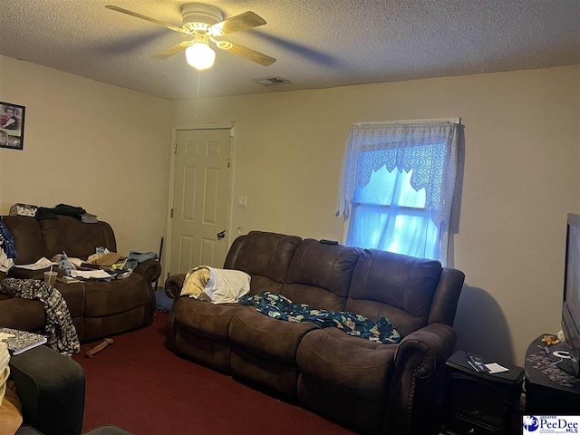 living room with ceiling fan, carpet, and a textured ceiling