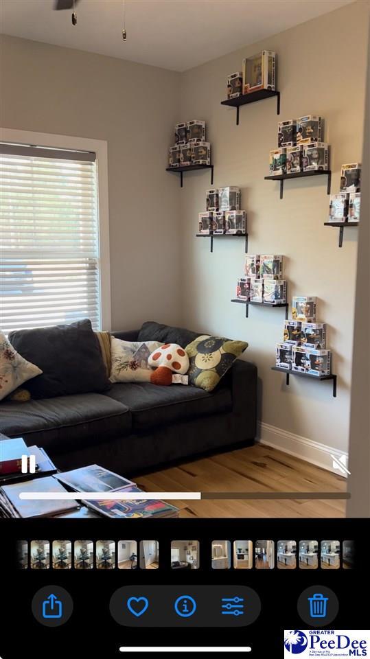 living area featuring baseboards and wood finished floors