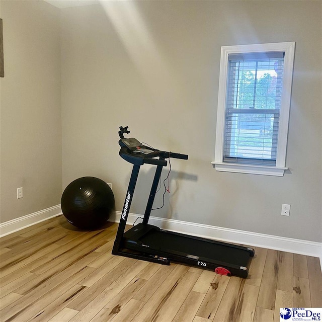 exercise area featuring baseboards and wood finished floors