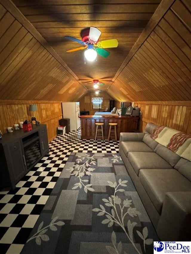 interior space with vaulted ceiling, wood ceiling, and wood walls