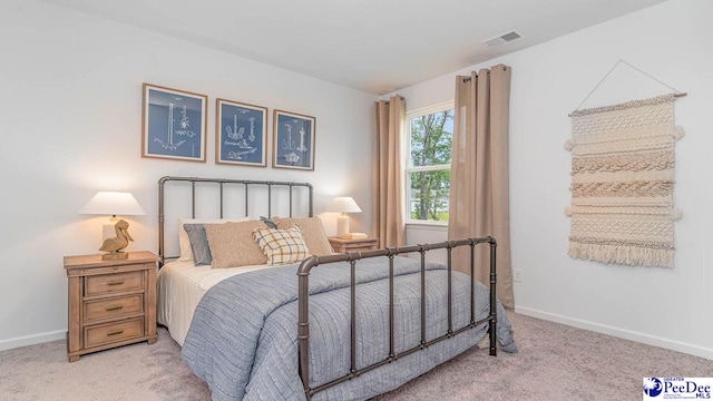 bedroom featuring baseboards, light carpet, and visible vents
