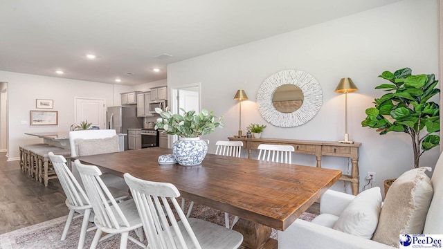 dining room featuring wood finished floors, baseboards, and recessed lighting