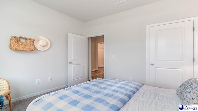 carpeted bedroom featuring baseboards and visible vents