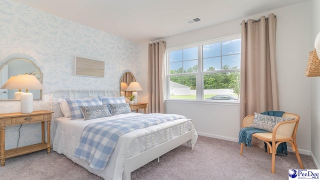 carpeted bedroom featuring wallpapered walls, visible vents, and baseboards