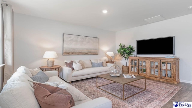 living room with recessed lighting, baseboards, visible vents, and wood finished floors