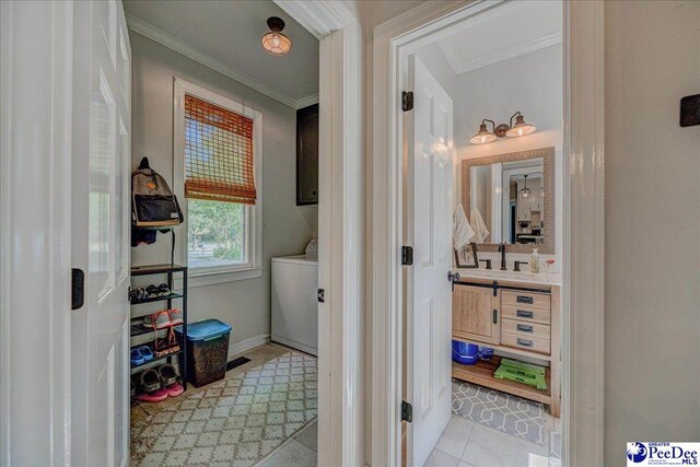 bathroom featuring crown molding, washer / clothes dryer, tile patterned floors, and vanity
