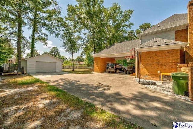 exterior space featuring brick siding, an outdoor structure, a garage, and roof with shingles