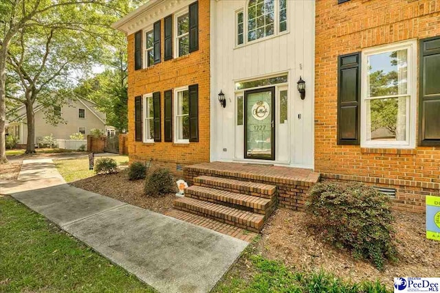entrance to property with brick siding and board and batten siding