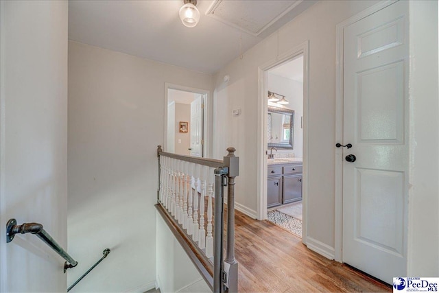 stairs featuring wood finished floors, attic access, and baseboards