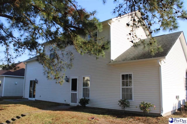 back of property featuring a lawn