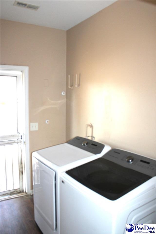 laundry room featuring laundry area, visible vents, independent washer and dryer, and dark wood-style flooring