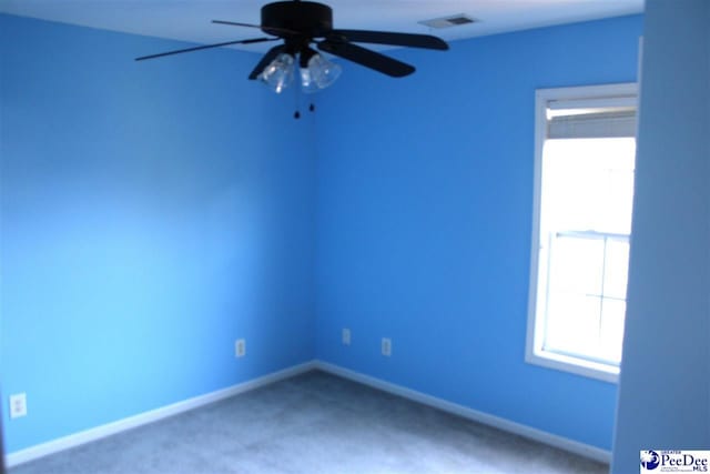 unfurnished room with visible vents, baseboards, carpet, and ceiling fan