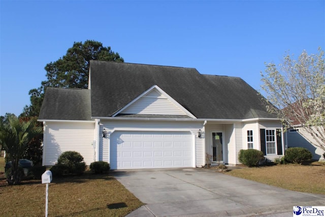 view of front of home featuring a garage, a front yard, roof with shingles, and driveway