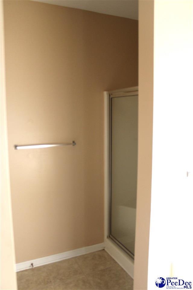 bathroom with baseboards and a stall shower